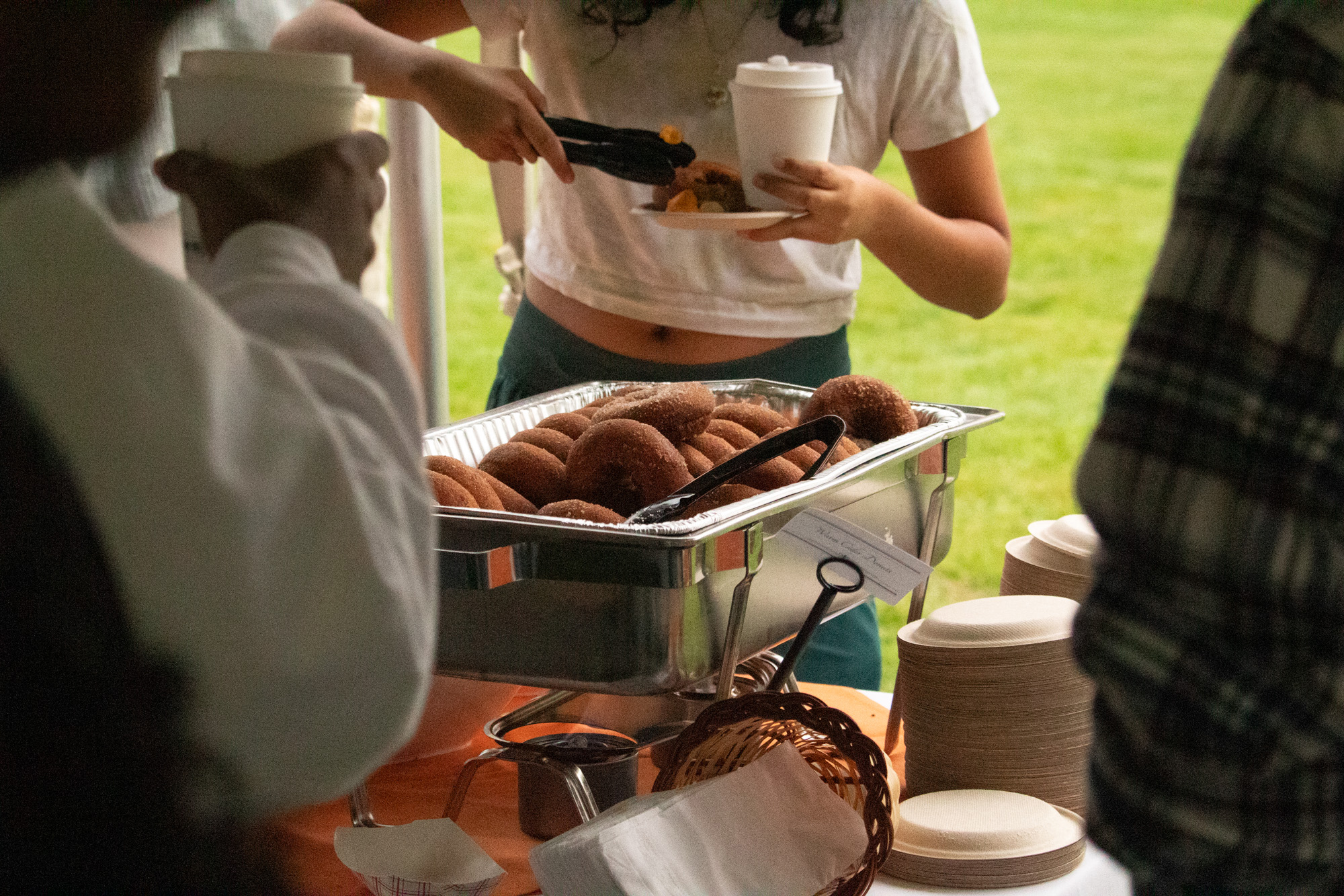 Students taking apple cider donuts.