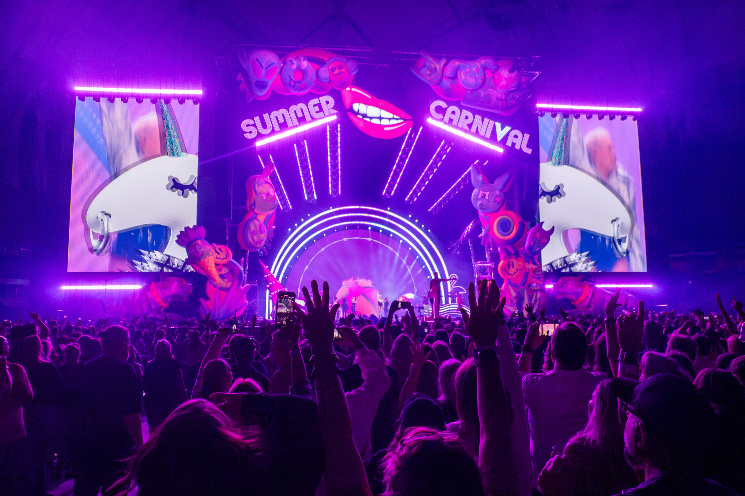 The stage glows with purple and pink lighting. Many concertgoers wore P!nk’s tour merchandise or donned other pink clothing to celebrate.
