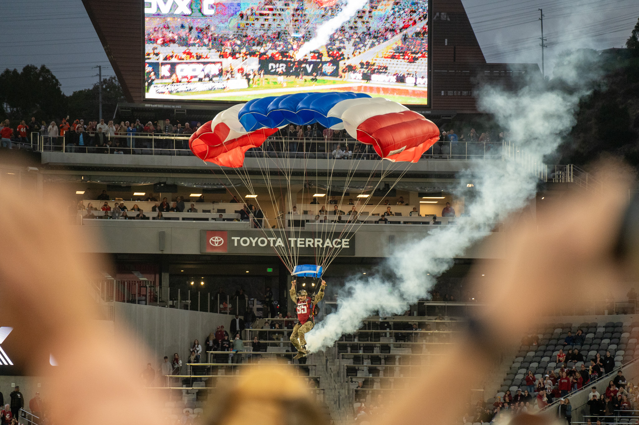 A paraglider flies in from the sky to land on the field pregame. As part of the Holiday Bowl, festivities included a helicopter flyover, halftime firework display and the pregame paragliders.