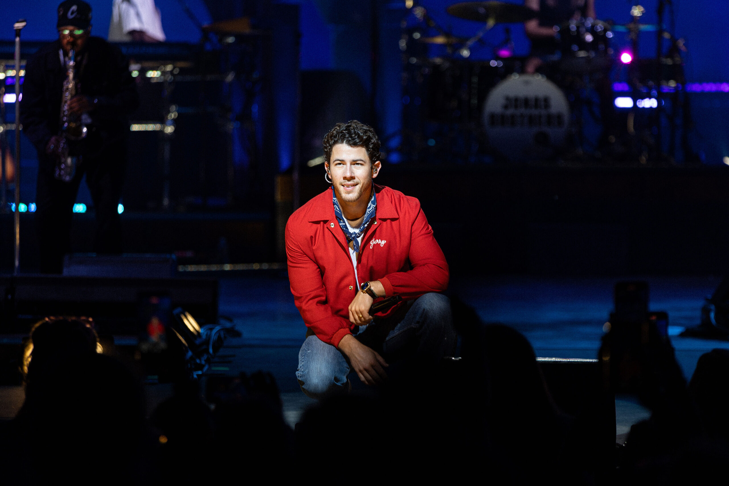 Nick Jonas kneels and locks eyes with the Syracuse crowd while performing. 