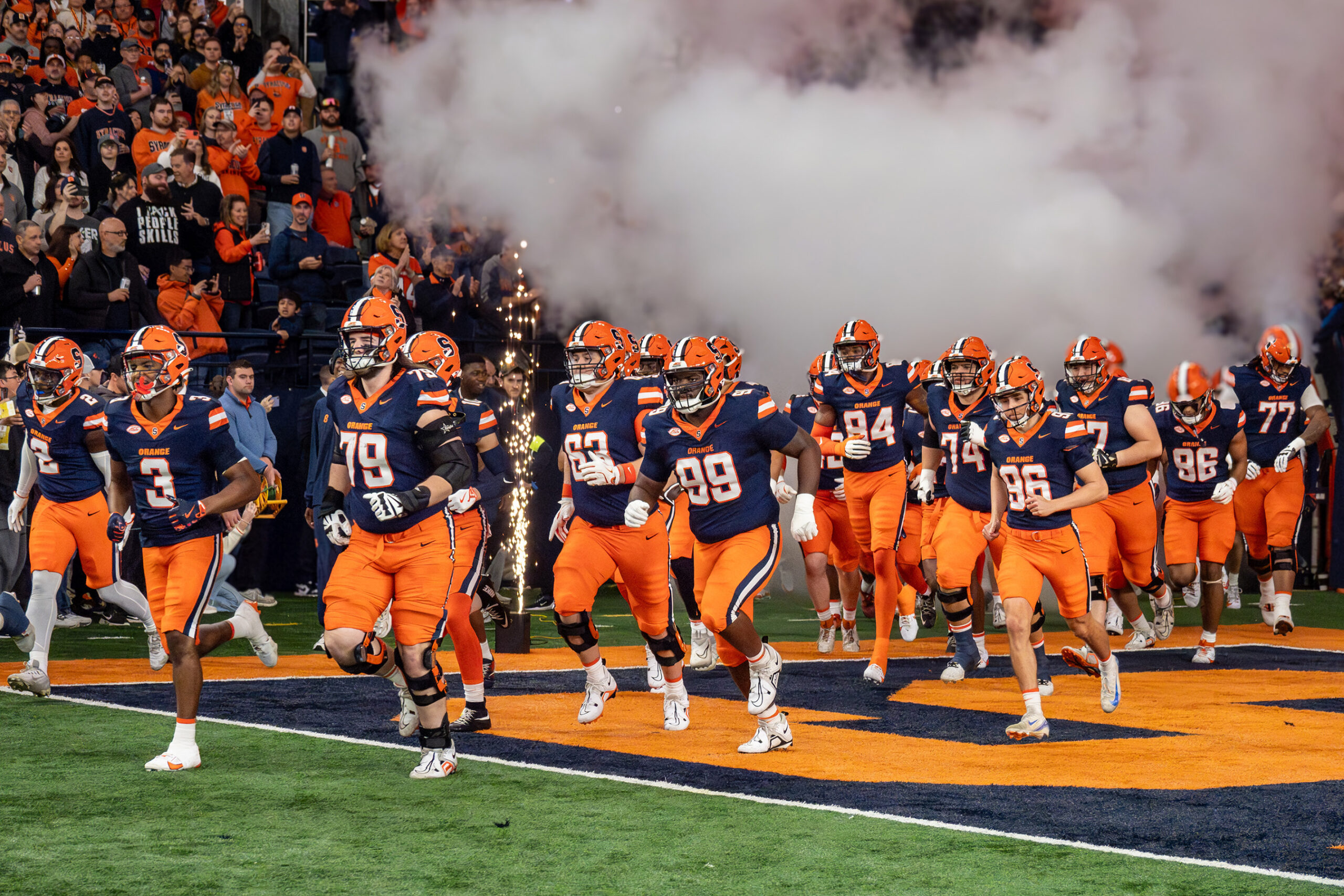 Photo of Syracuse football players emerging from the tunnel at the start of a home game in the JMA Wireless Dome.
