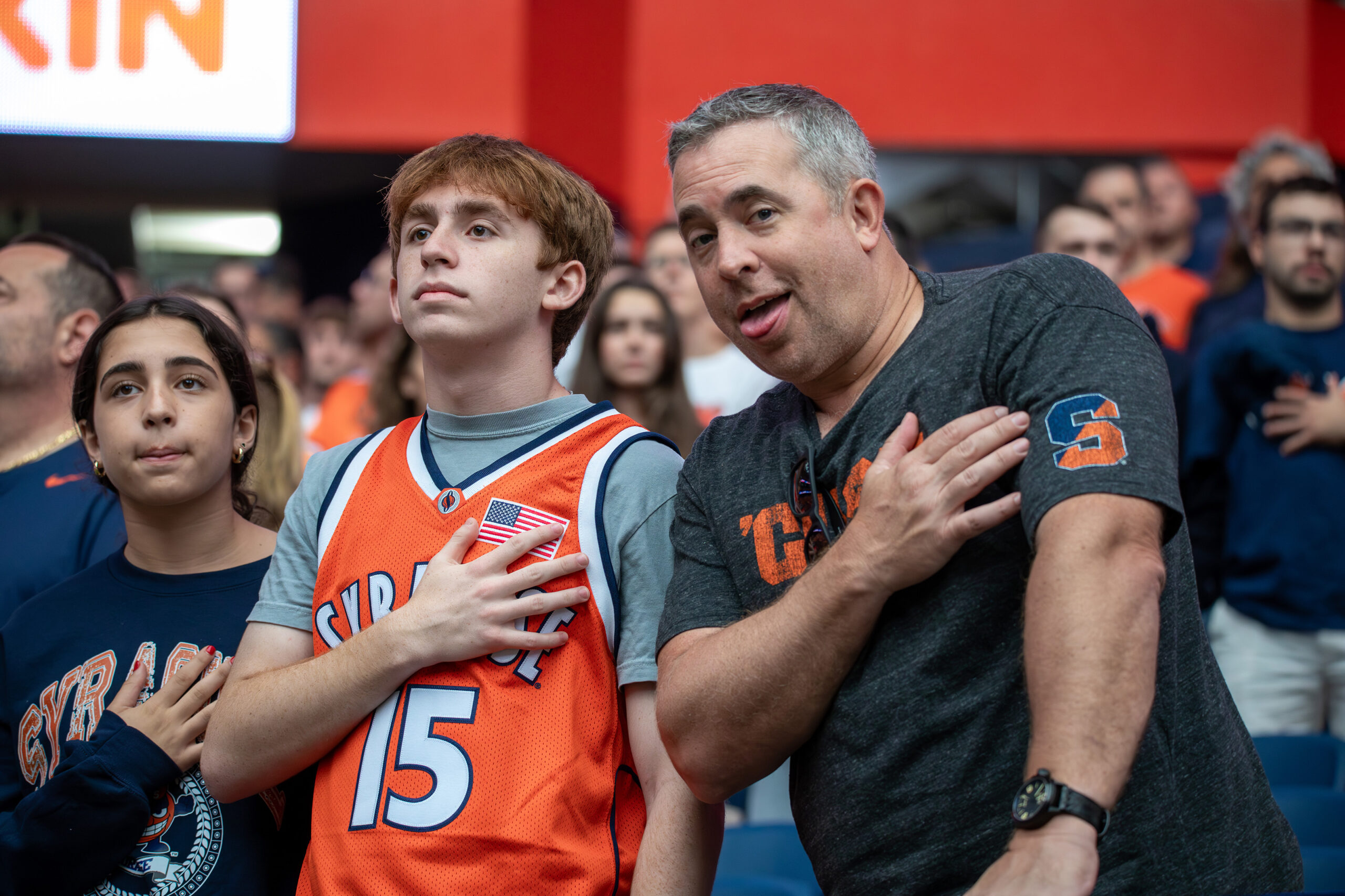 Orange fans stand for the national anthem before football’s noon kickoff. Parents and their children shared cheers, laughs and funny faces during this weekend’s events.