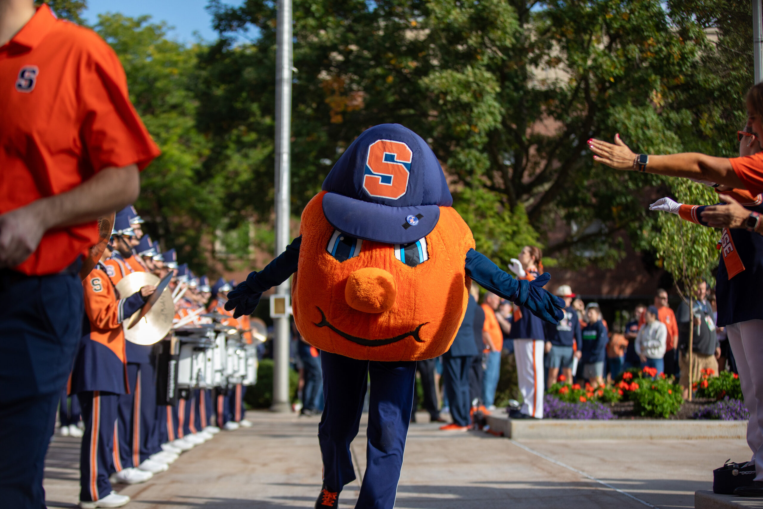Otto the Orange runs out during football’s Quad Walk in front of fans and parents. Families lined Shaw Quadrangle before the football game to see the team walk off to the Dome.