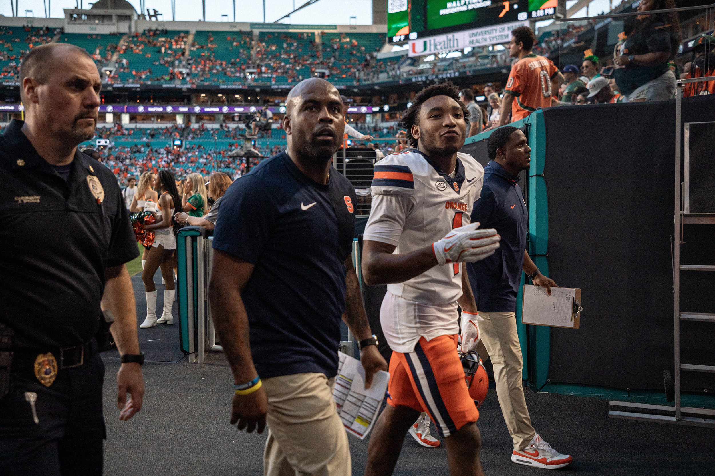 Syracuse head coach Fran Brown walks off the field alongside freshman defensive back Demetres Samuel Jr., who tied his season-high with five solo tackles against the Hurricanes.