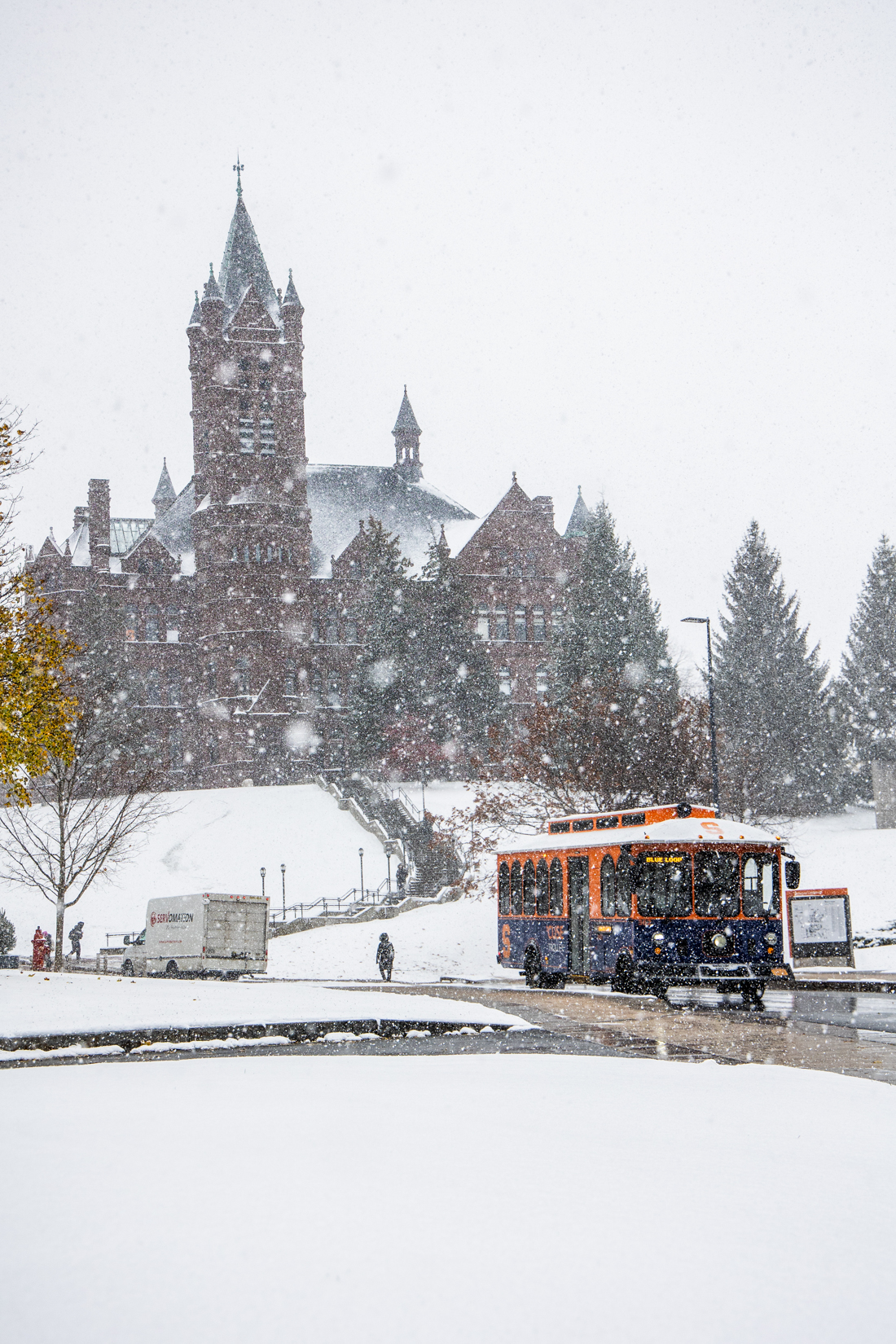 An ‘Cuse Trolley departs from campus down Crouse Drive in the snowfall. Some students sled down Crouse Hill when it snows. 