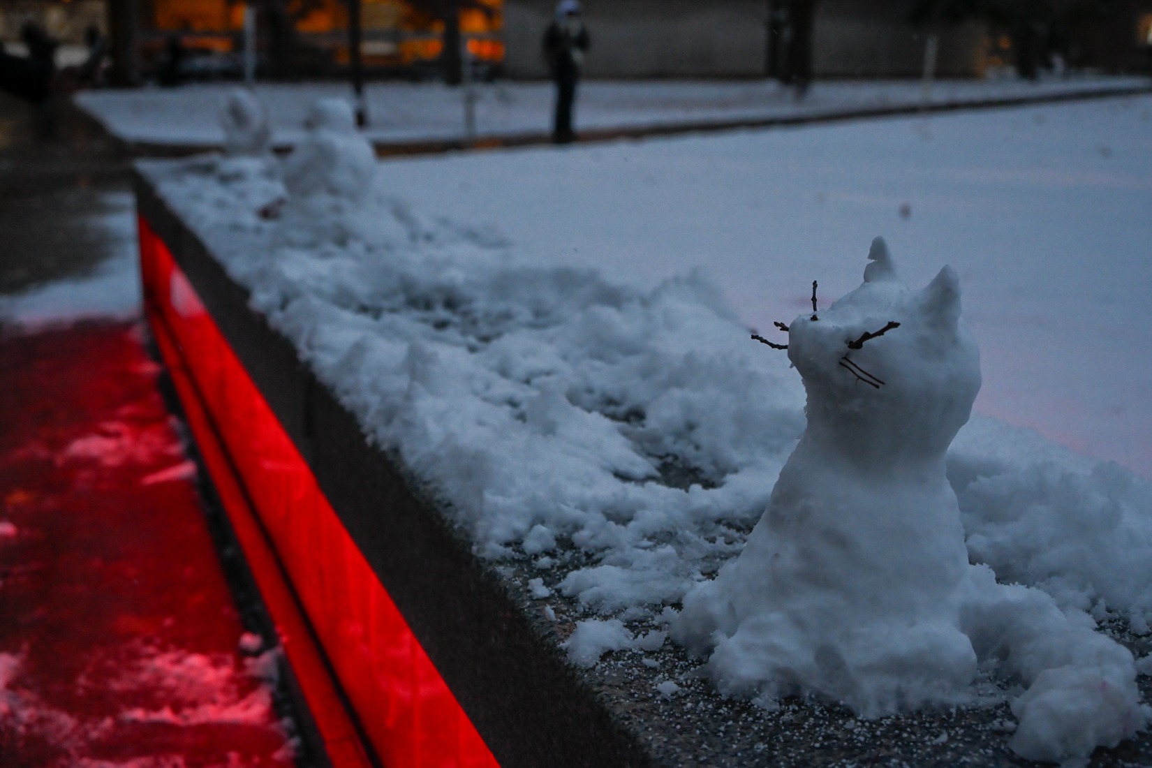 A cat made from snow sits among other snow sculptures outside of Hendricks Chapel.