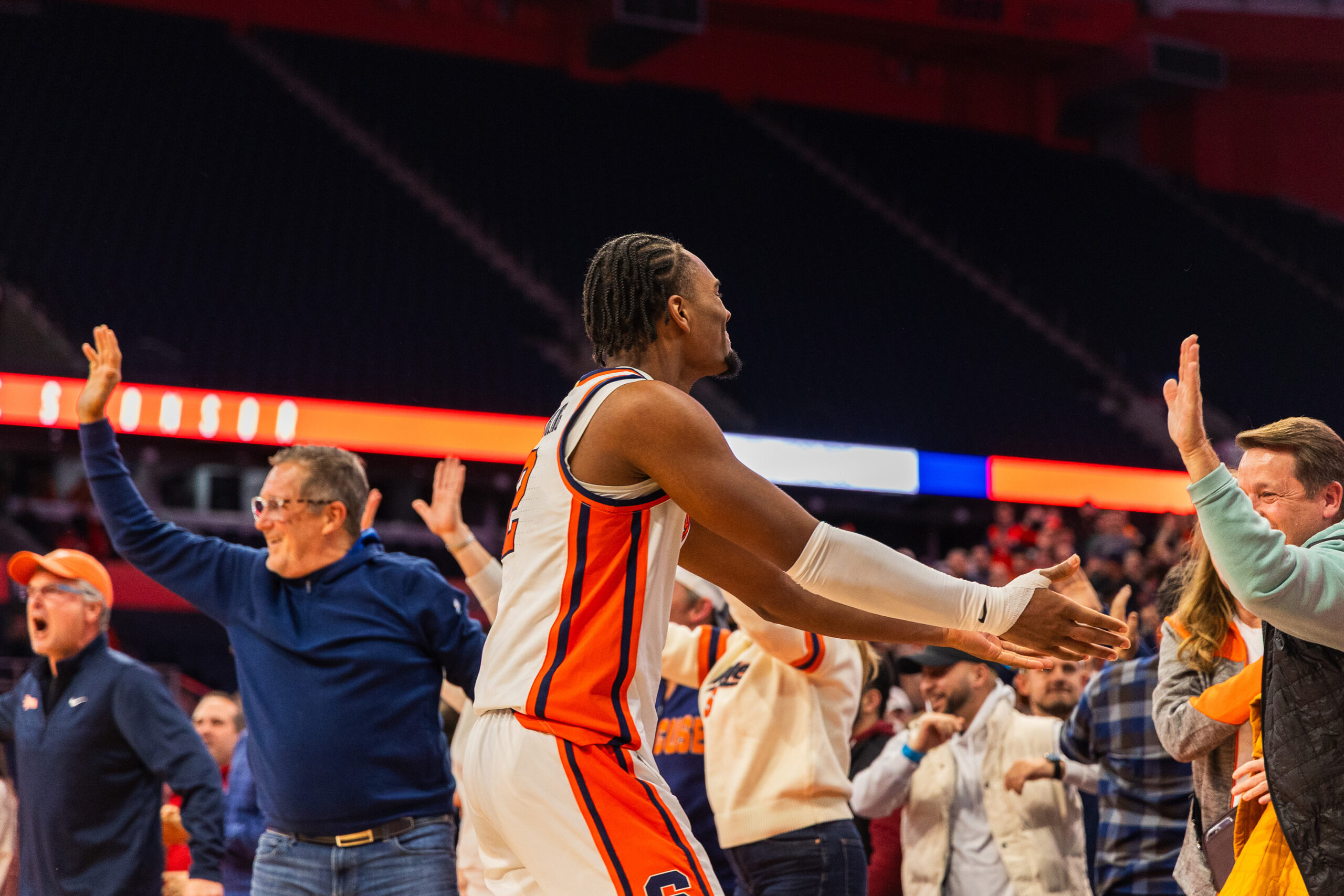 Syracuse star guard J.J. Starling extends his hands to celebrate Tuesday’s win over Tennessee with an SU fan. Despite scoring one first-half point, Starling drained multiple clutch buckets down the stretch to lift the Orange to victory.