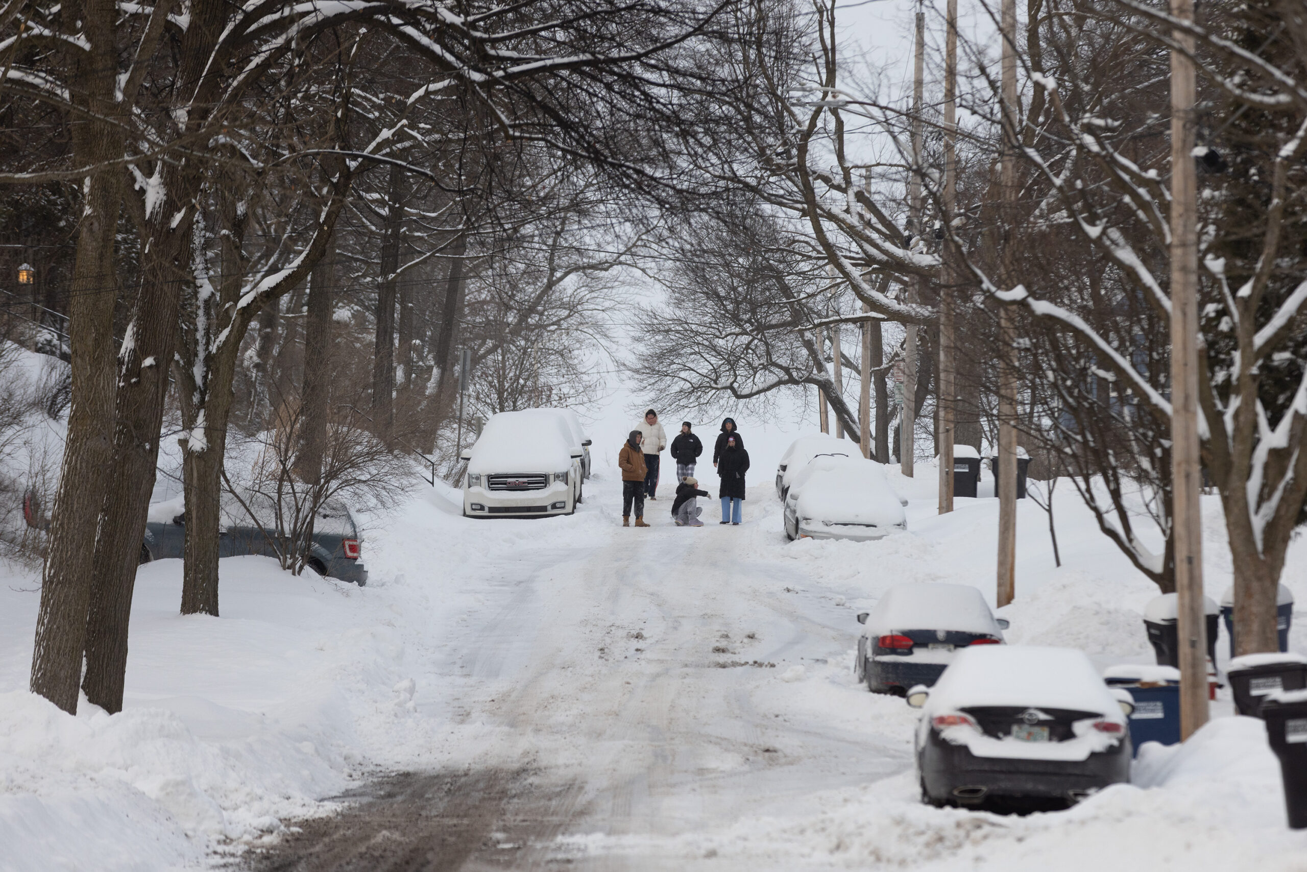 A group of people surveyed the snowfall Monday morning. Cold temperatures and unplowed roadways led many to travel on foot.