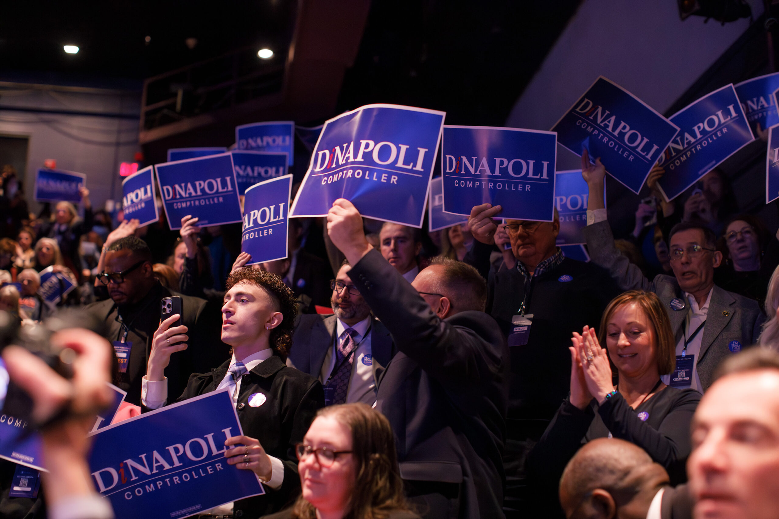 Convention attendees hold up signs in support of New York Comptroller Tom DiNapoli. DiNapoli’s apparent support dwarfed that of his lone challenger, Drew Warshaw — who only received 10% of members’ votes.
