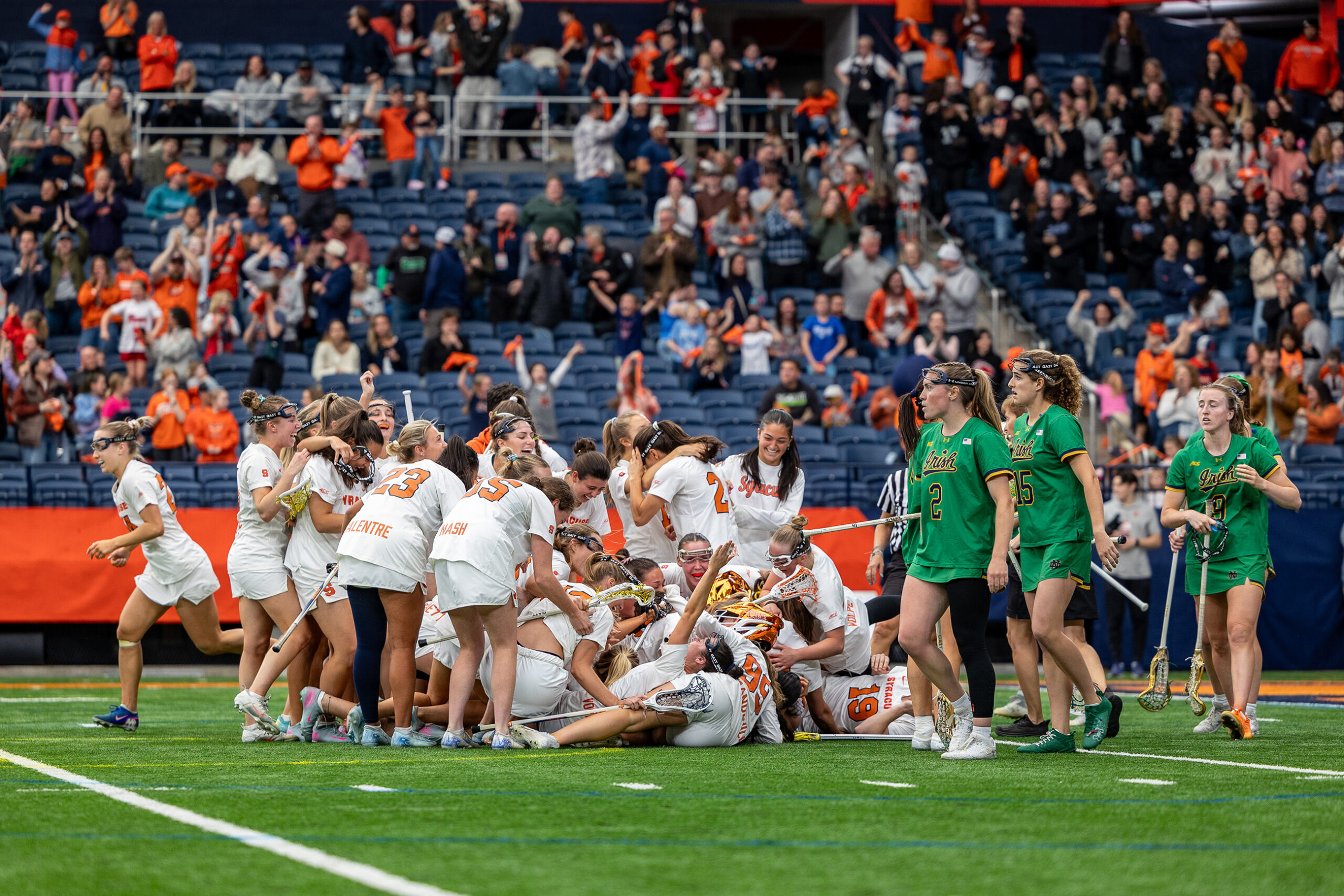 Syracuse women’s lacrosse dogpile in celebration after defeating Notre Dame 10-9 in quadruple overtime Saturday. The 80-minute epic was the longest game in program history and extended the Orange’s winning run to 12 games.