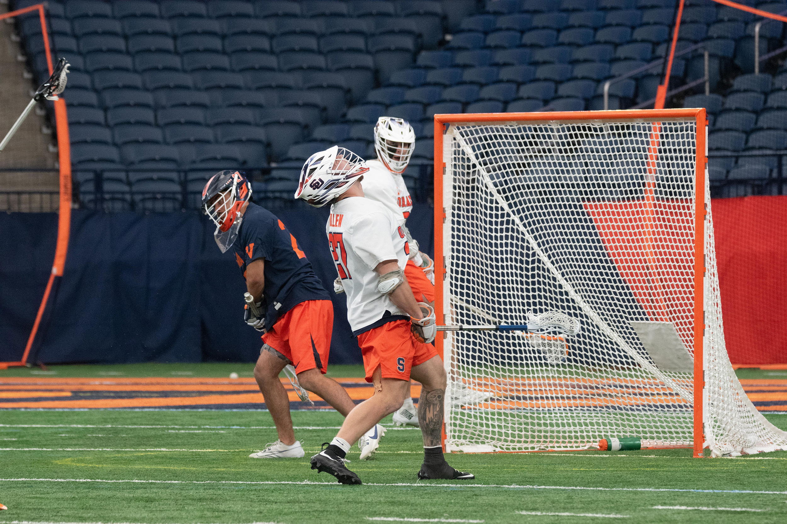 Syracuse faceoff man John Mullen (white) looks to the roof of the JMA Wireless Dome after he scored in the Orange’s 14-9 win over Virginia. Despite the win and goal, Mullen recorded a 36.4% faceoff winning percentage. 
