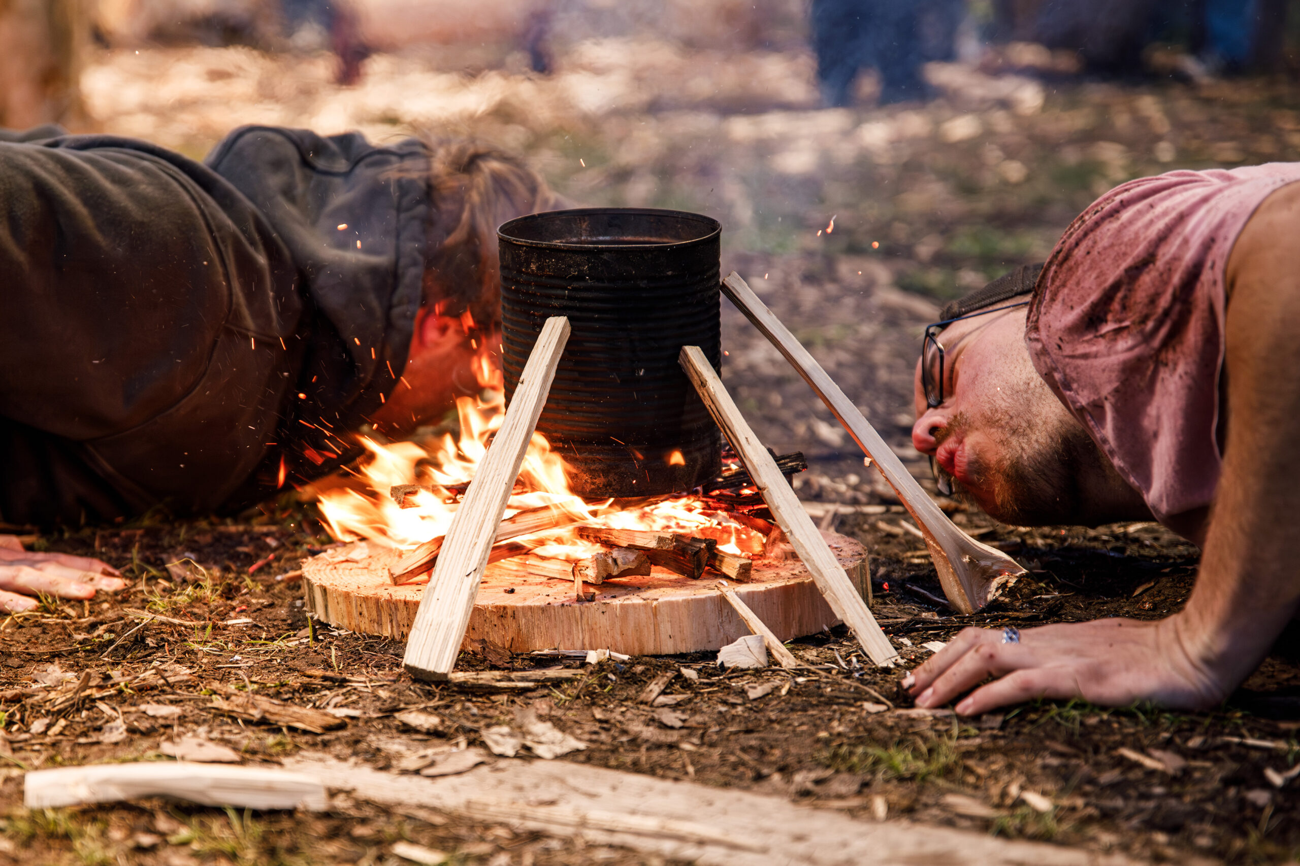 Kennon Gardner and Dziergas practice fire building, a doubles event. After building a small log cabin fire, they use their breath to keep the flame underneath the can until water inside boils over.
