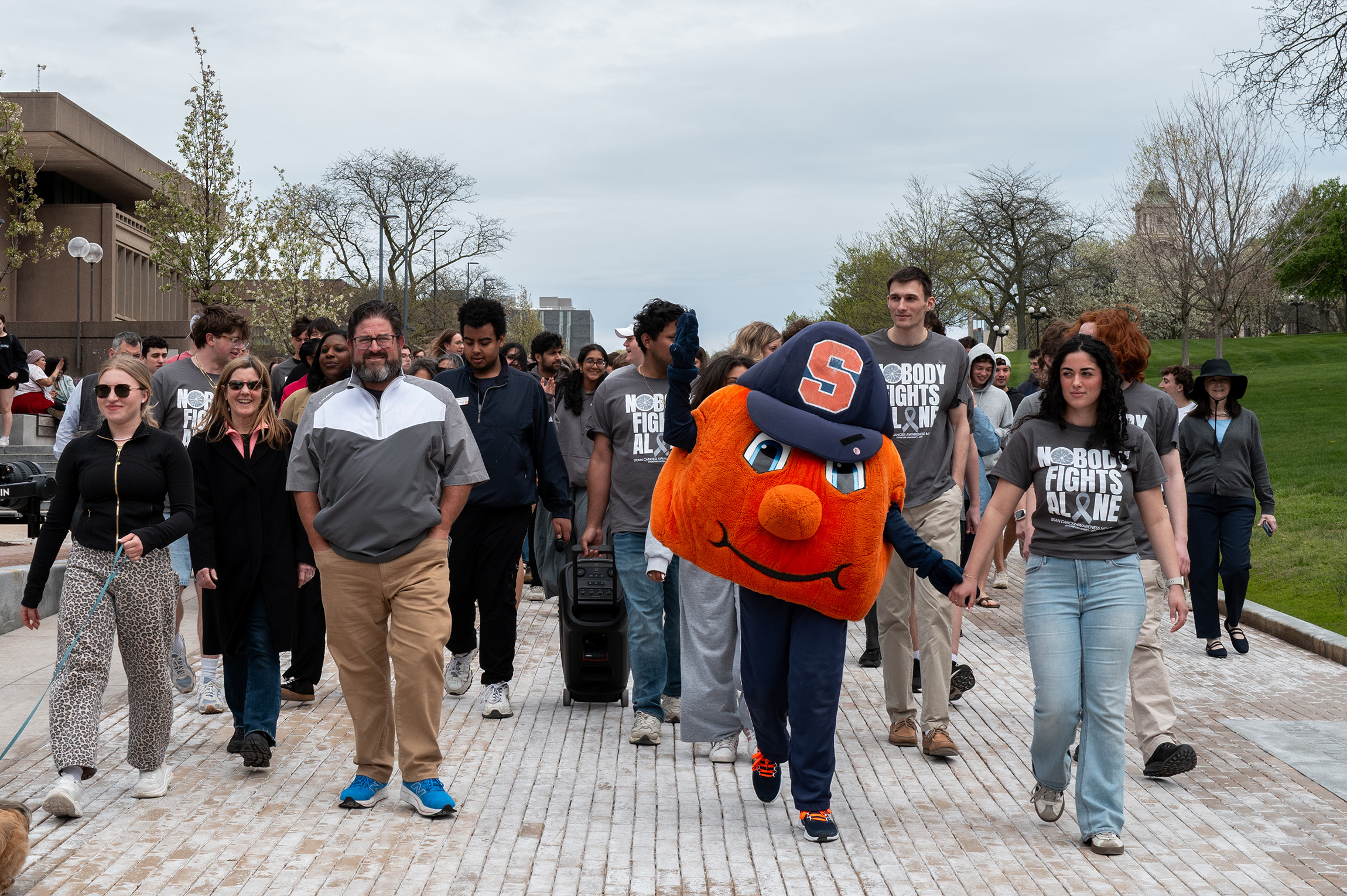 Current and former SGA executives, alongside Otto the Orange, lead the walk for Syverud. Student organizations represented their respective groups, with over 60 organizations appearing throughout the crowd.