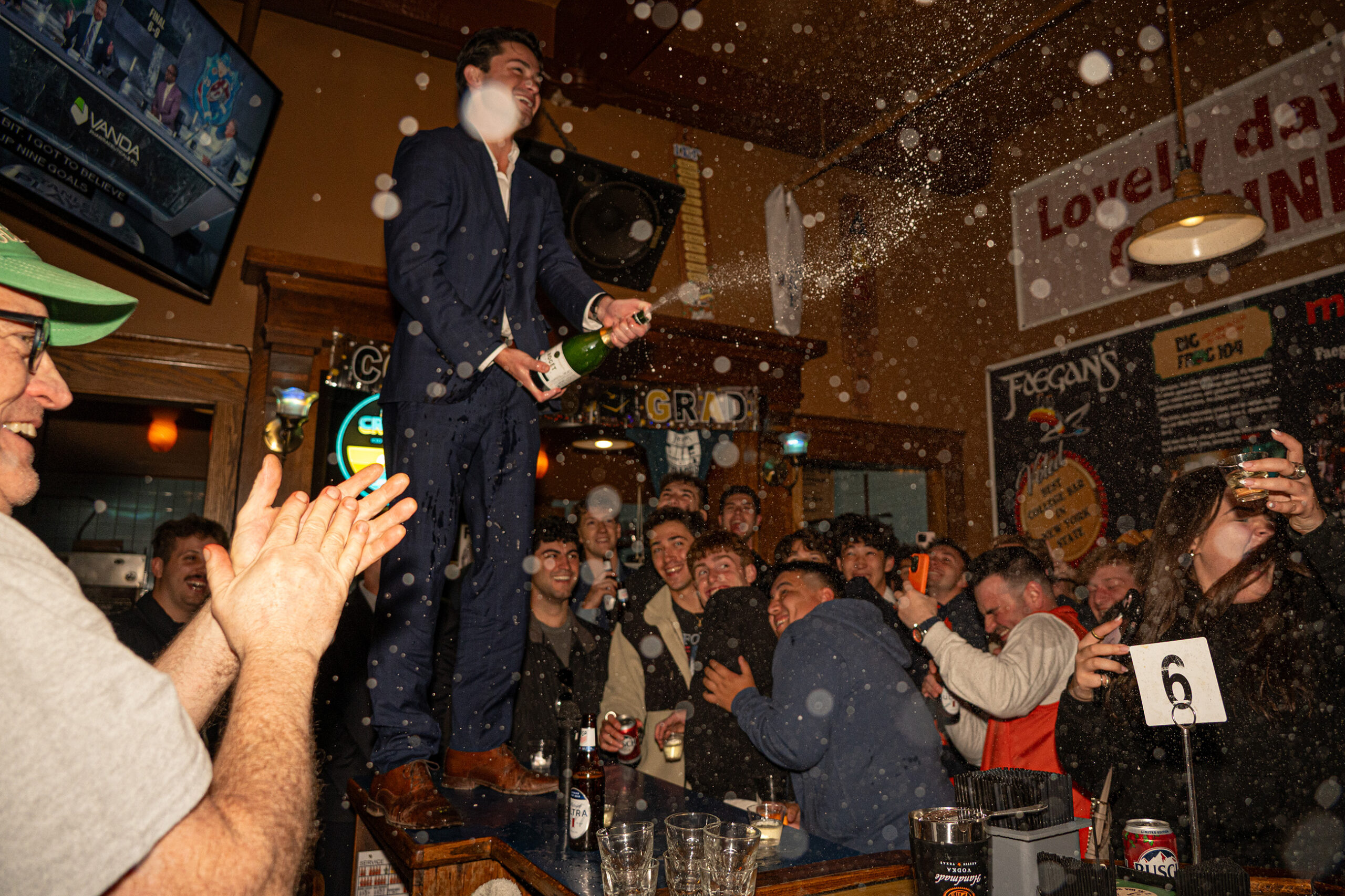 May 3, 2026: SU senior Jake Warcaba pops open a champagne bottle at Faegan’s Cafe &amp; Pub’s annual Senior Blow-Out. This year, Warcaba delivered a speech.