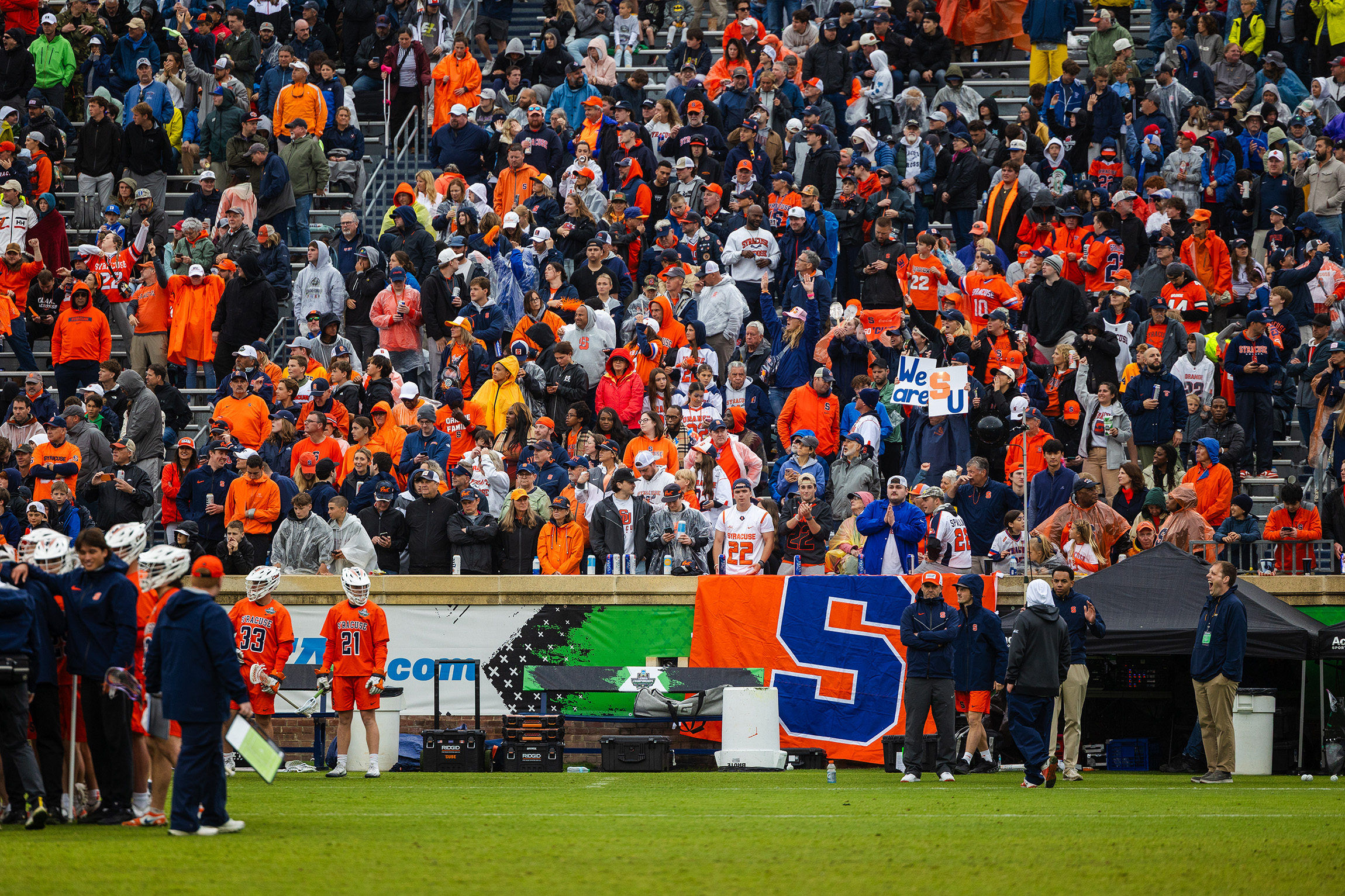 A large group of Syracuse supporters rises behind SU’s sideline at Scott Stadium, the host of the Final Four. Saturday’s game drew a crowd of 24,396 people.