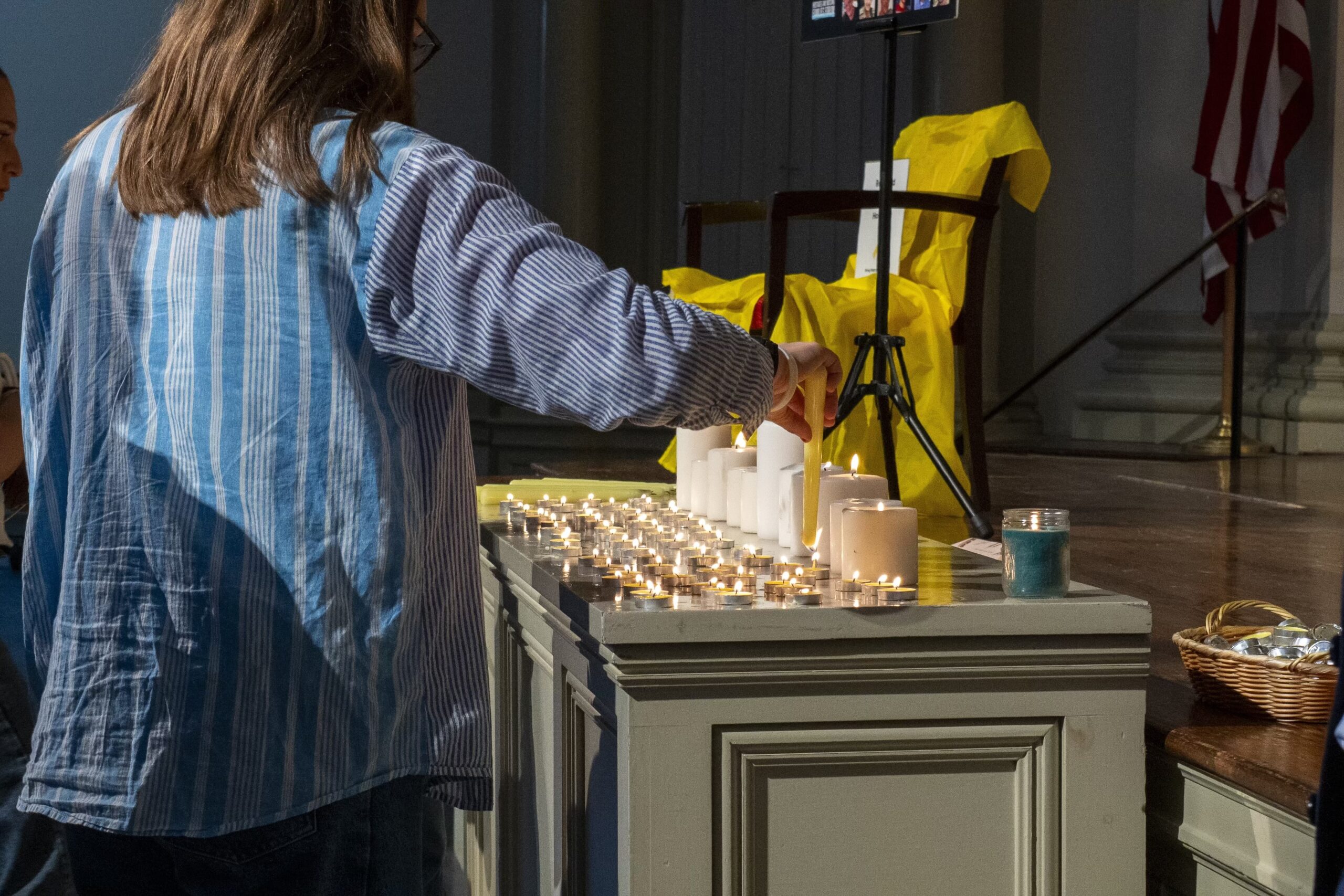 student lighting candle