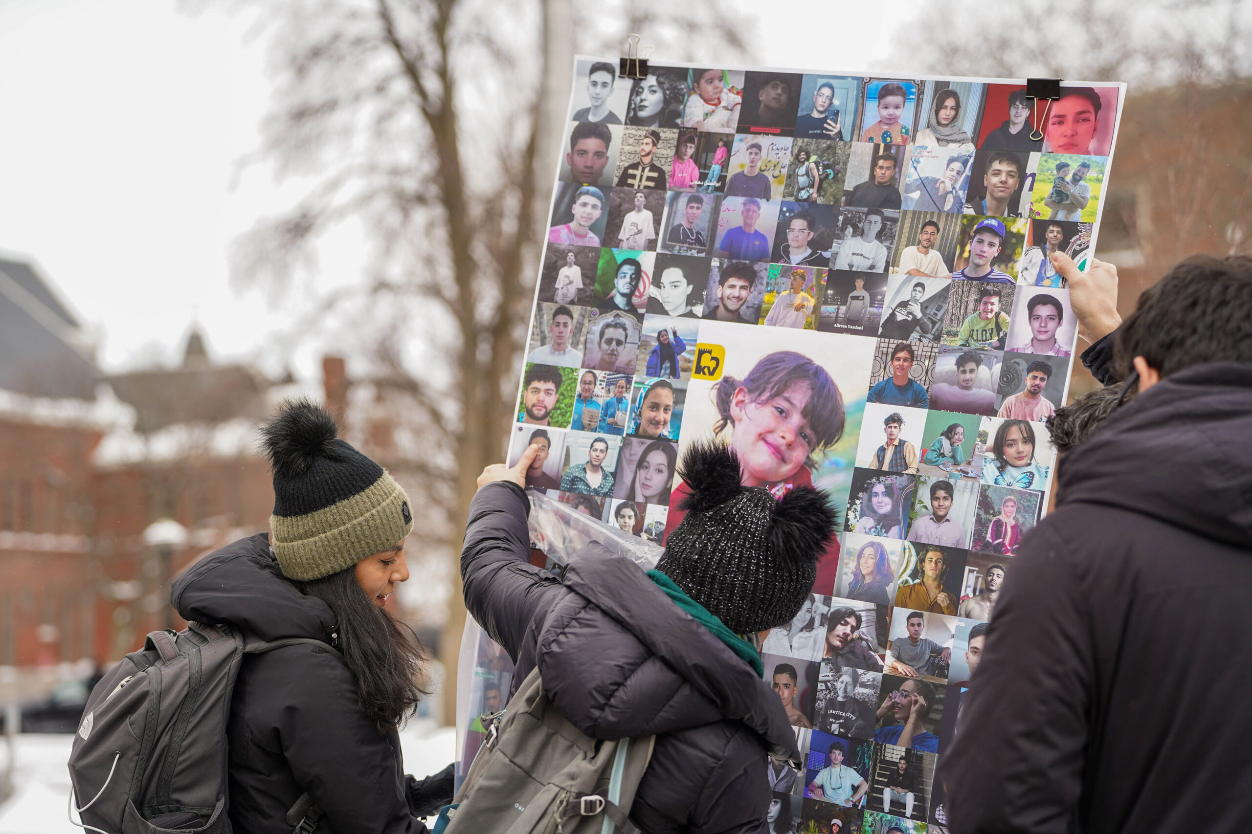 Protester holds sign with images of children.